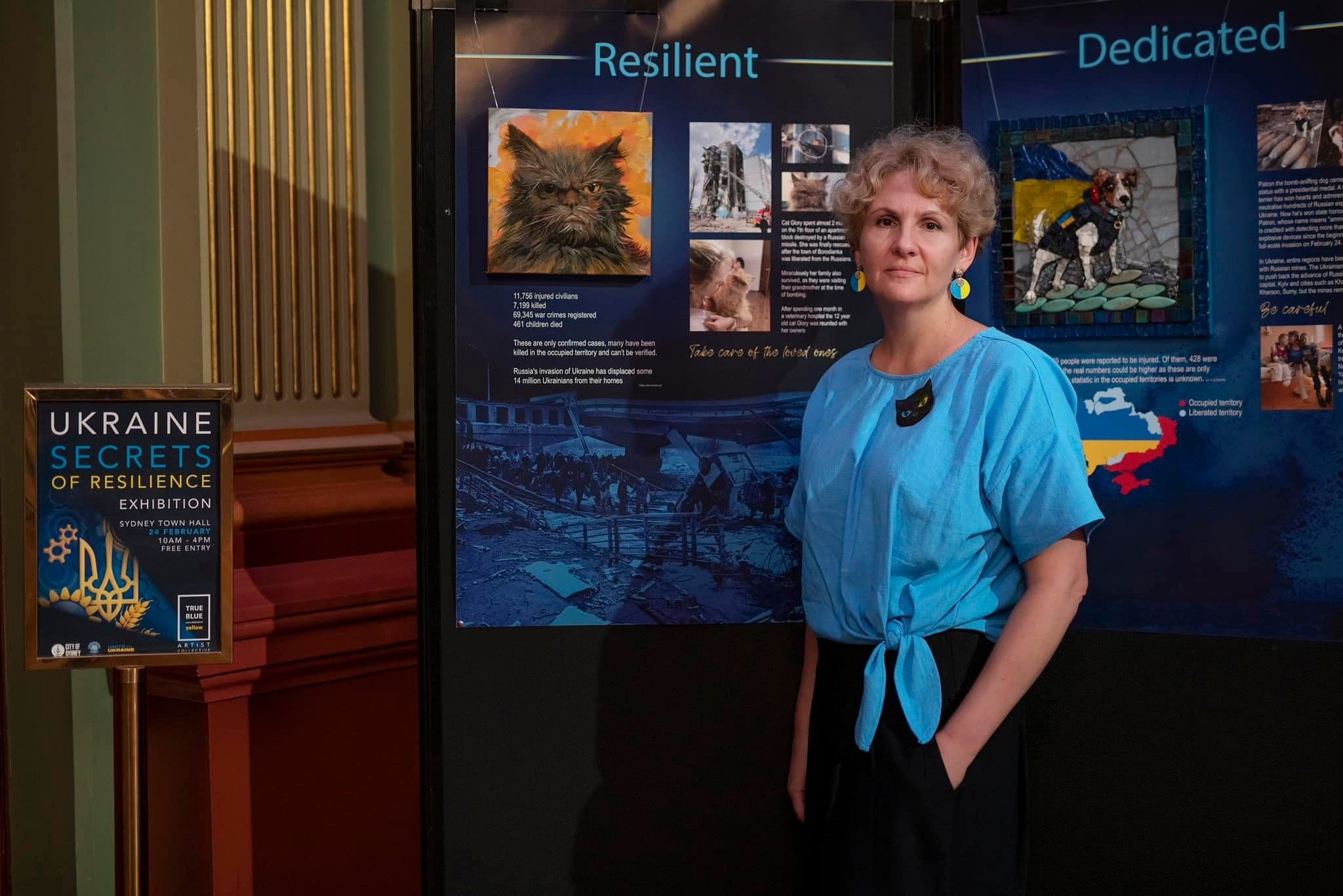 Tetiana next to the exhibition posters