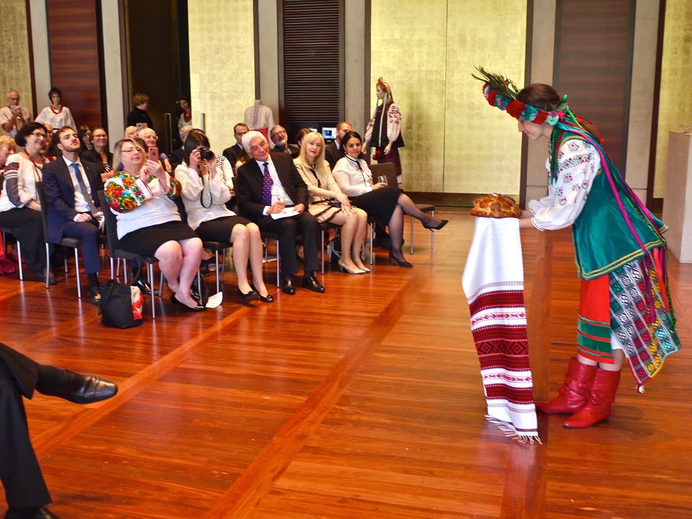 Diplomatic guests are watching a model welcoming them to the show